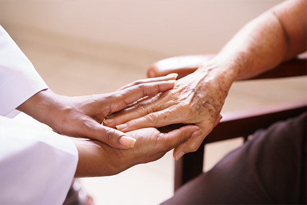 Young woman holding older man's hand